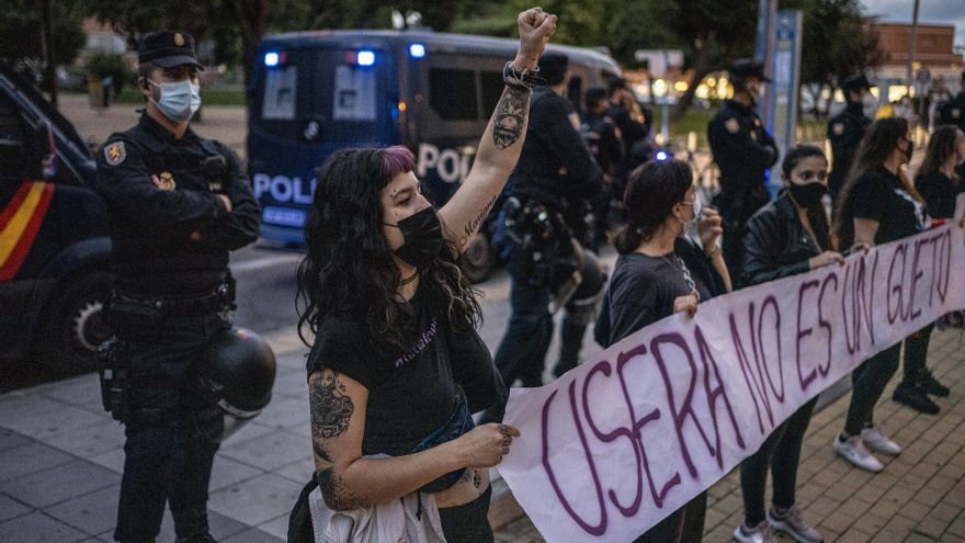 Manifestantes con la pancarta 'Usera no es un gueto, Usera se defiende', junto a efectivos de la policía nacional