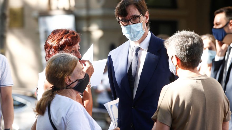 El ministro de Sanidad Salvador illa (c) conversa con asistentes a la ofrenda floral en las Ramblas. EFE/Quique Garcia