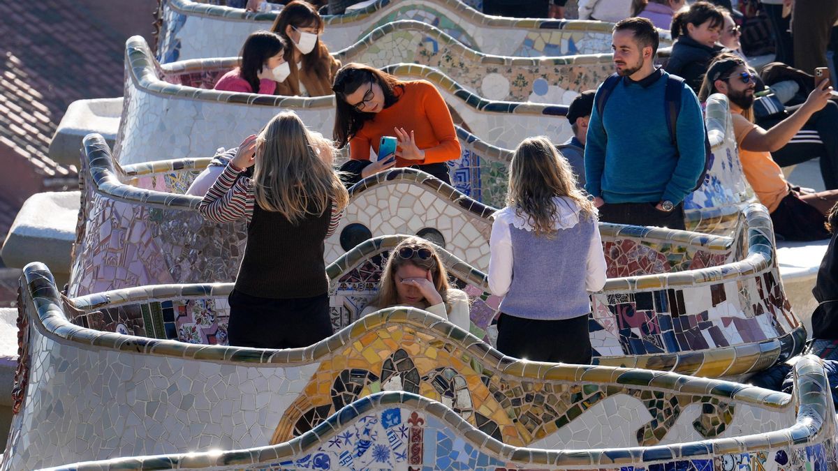 Numerosas personas disfrutan del buen tiempo en el Parc Güell de Barcelona este jueves. EFE/Enric Fontcuberta