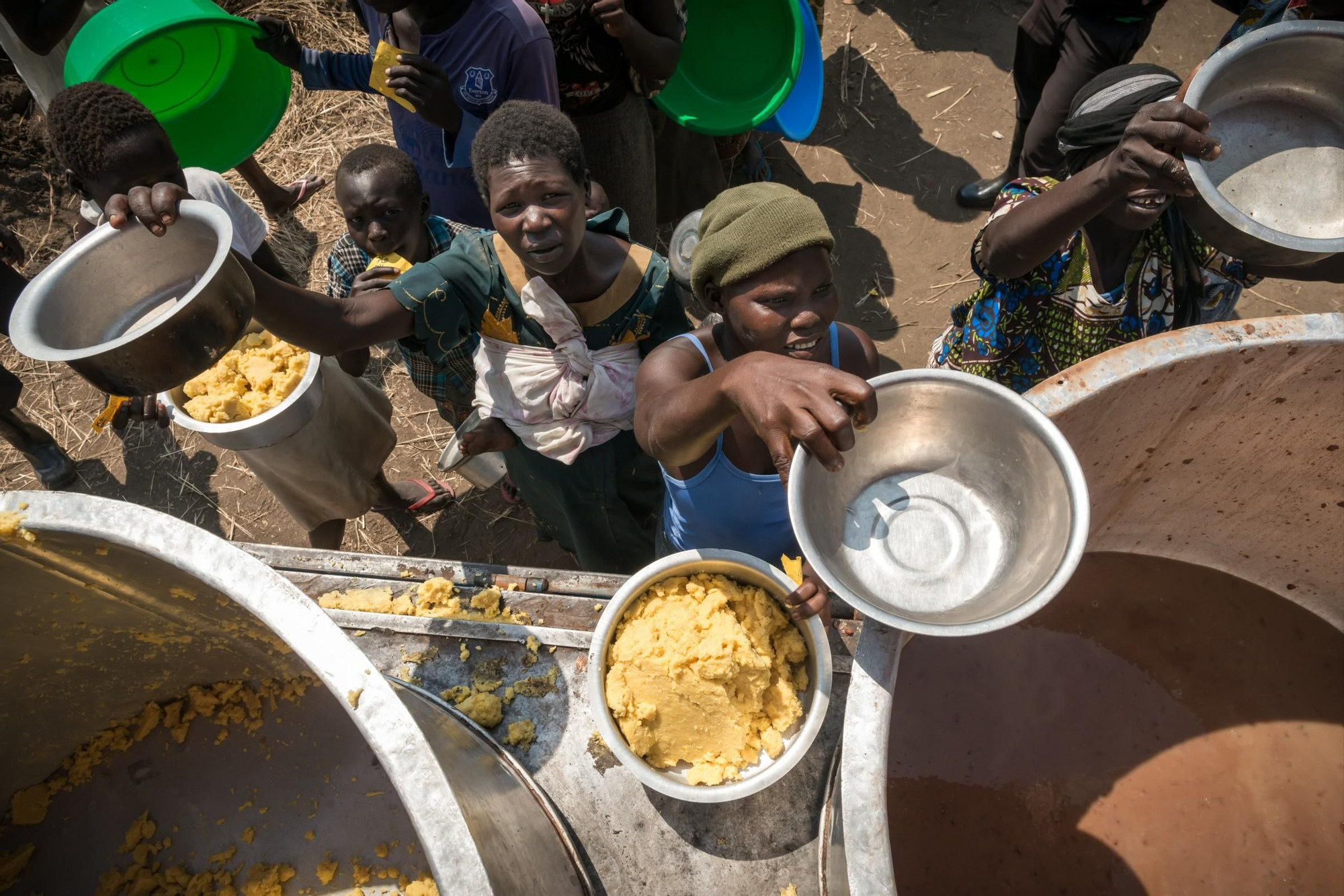 Hasta que puedan cocinar por sí mismos, reciben comidas preparadas a base de avena y frijoles. Los refugiados llegan a su lugar de asentamiento temprano en la mañana y tienen menos de un día para instalarse. Son asistidos por las autoridades y organizaciones humanitarias internacionales. Fotografía: Yann Libessart/MSF