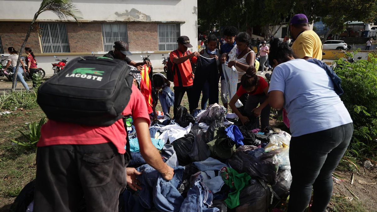 Personas toman donaciones este viernes, en La Guaira (Venezuela).