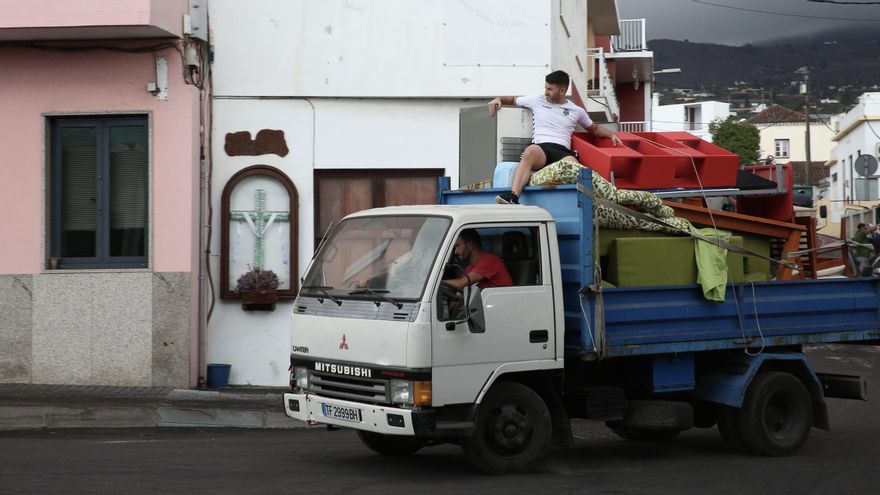 Un joven subido a una furgoneta con muebles sale de la última zona evacuada en La Palma por el volcán