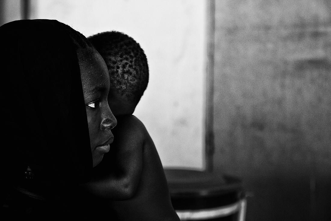 Una madre con su hijo en brazos espera su turno en el centro de recuperación infantil nutricional de Virimadjo en Bamako (centro referencial, para la recuperación de niños desnutridos) de la comuna 6 de Bamako, la más pobre de la capital Maliense. | ÁNGEL COLINA (17/04/2014)