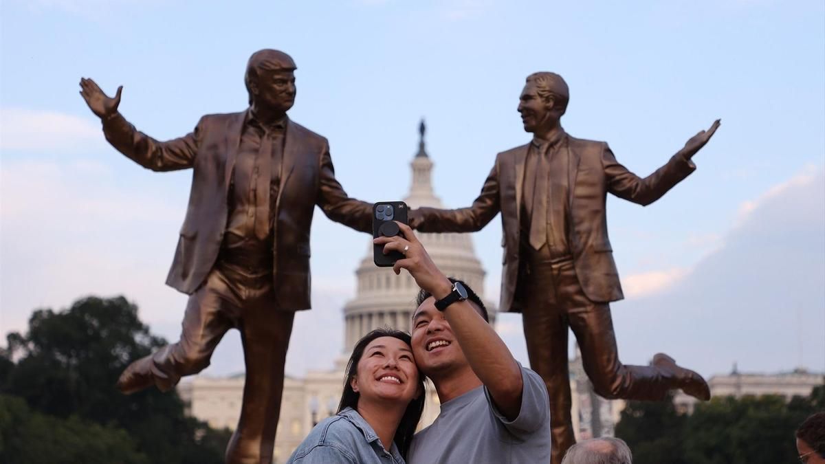 Una pareja se fotografía frente a la estatua de Donald Trump y Jeffrey Epstein que ha aparecido en el National Mall de Washington DC esta semana