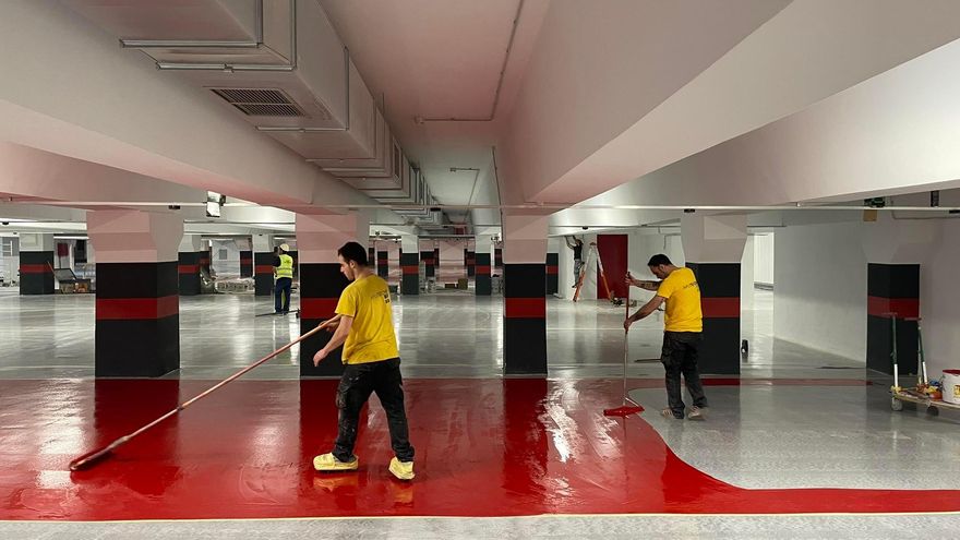 Los técnicos pintan las plazas del aparcamiento de la plaza de la Reina.