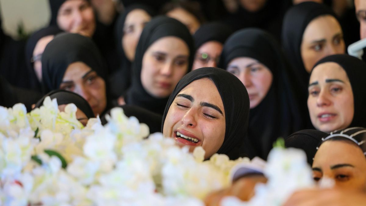 Una mujer llora ante el féretro de la periodista asesinada por Israel Amal Khalil