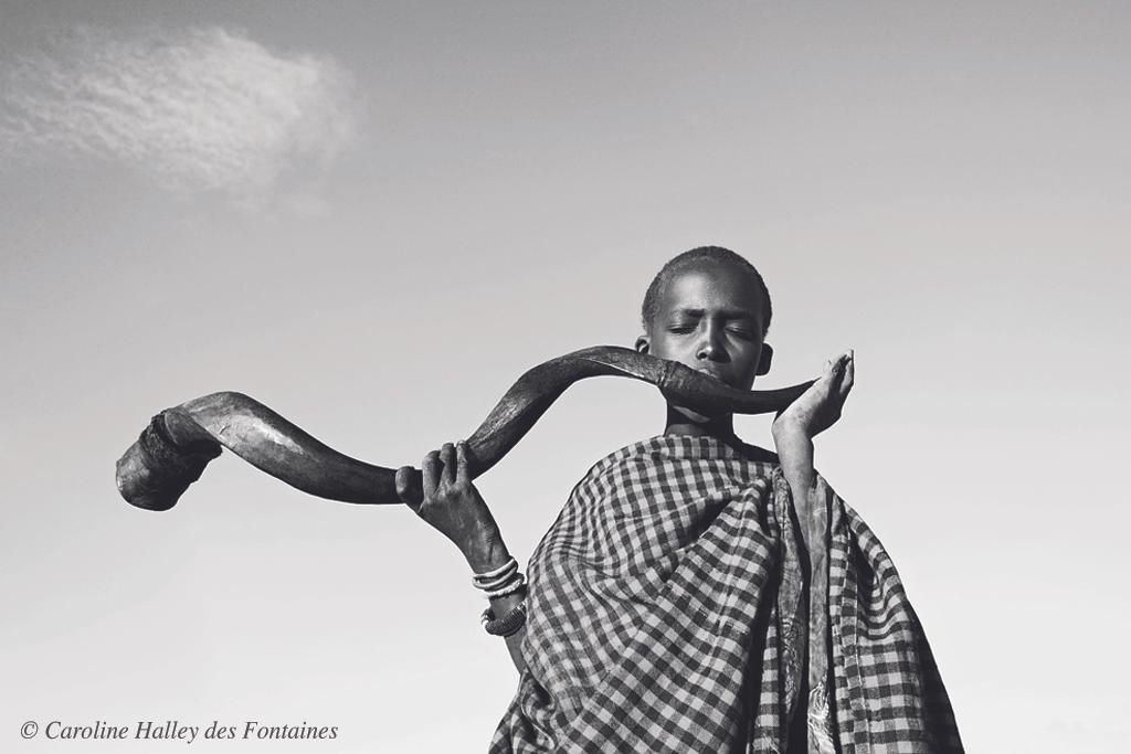 Los festivales tribales también rinden homenaje a los diferentes ciclos de la vida humana. En el este de África, un joven masái toca el cuerno de un gran antílope kudu para reunir a los moranes para la ceremonia del e unoto, que anuncia la transición de adolescente moran a adulto. La ceremonia consiste en varios días de cantos y danzas./ Fotografía: ©Caroline Halley des Fontaines