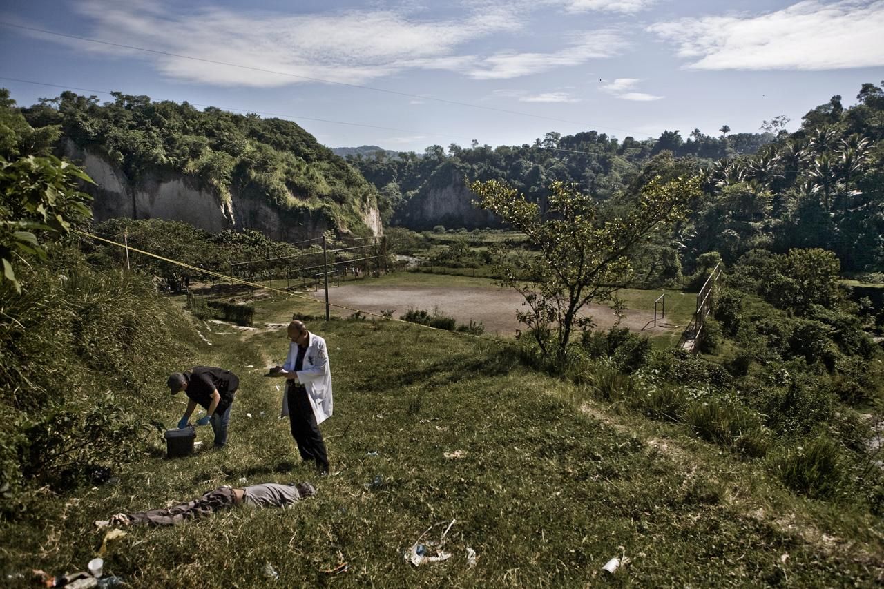 Abullarade inspecciona un cadáver en los alrededores de La Campanera, un vecindario controlado por la pandilla conocida como Barrio 18./Edu Ponces (RUIDO Photo)