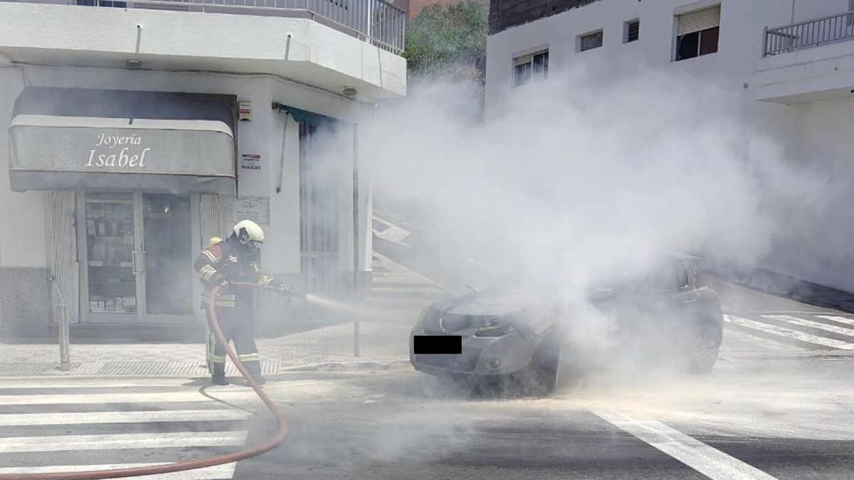 Un bombero  apaga el incendio de un coche en el centro urbano de El Paso, este jueves.