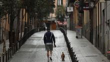 Un hombre pase a su perro en el madrileño barrio de Malasaña.