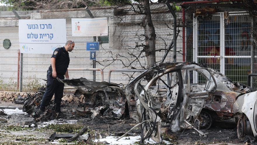 Un policía israelí inspecciona coches calcinados tras el impacto de fragmentos de un misil balístico iraní interceptado en Tel Aviv, Israel, el 15 de marzo de 2026.  EFE/EPA/ABIR SULTAN