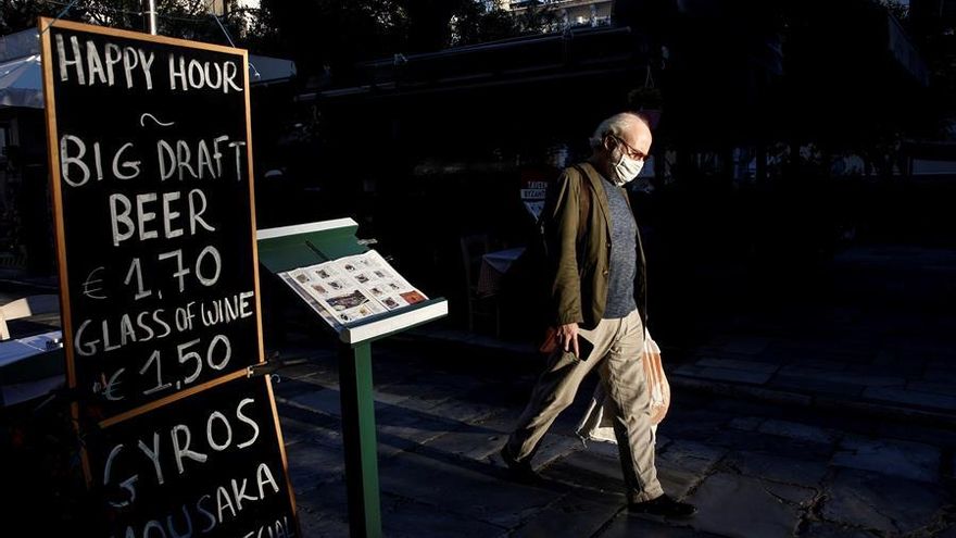 A man wearing a mask walks by a restaurant at the tourist district of Plaka in central Athens, Greece, 31 October 2020. Greece will shut down, for the first time since May, restaurants, bars, cafes, cinemas and gyms across a great part of the country after a surge in coronavirus cases. Greek Prime Minister announced new measures which will take effect 03 November 2020 and will last for a month. (Cine, Grecia, Atenas) EFE/EPA/YANNIS KOLESIDIS
