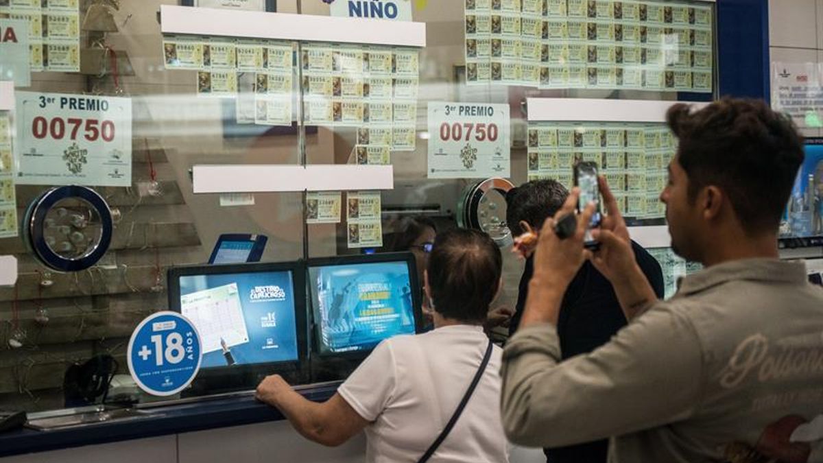 Imagen de archivo de personas comprando lotería de Navidad en una administración.