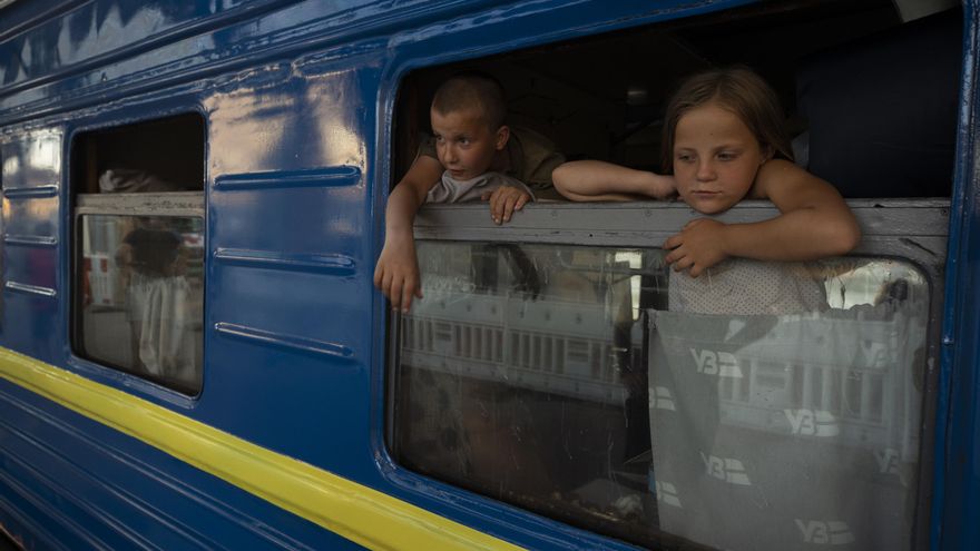 Niños observan desde un vagón, donde van las personas que huyen de las zonas de combates en un tren de la "Ukrzaliznytsia", la empresa estatal de ferrocarriles, ayer en Dnipro (Ucrania). EFE/Orlando Barría