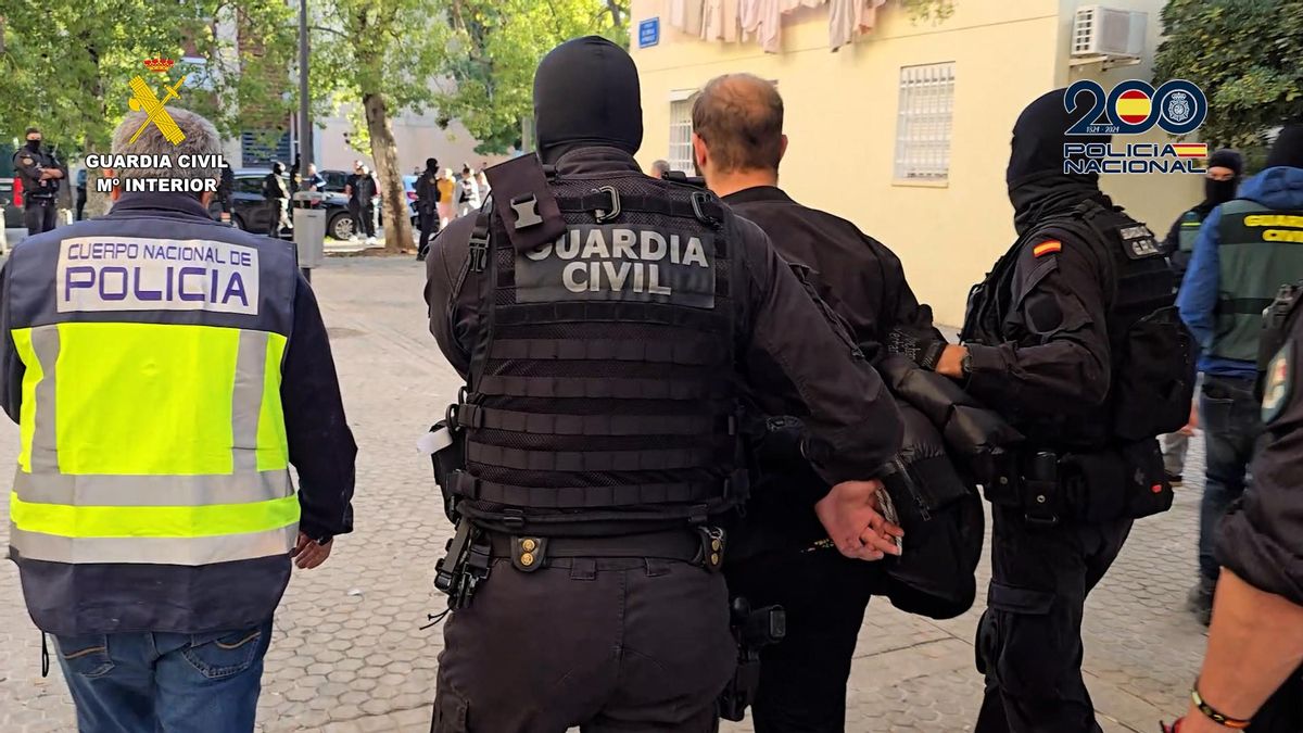 Agentes de la Guardia Civil y la Policía Nacional conducen a uno de los arrestados.