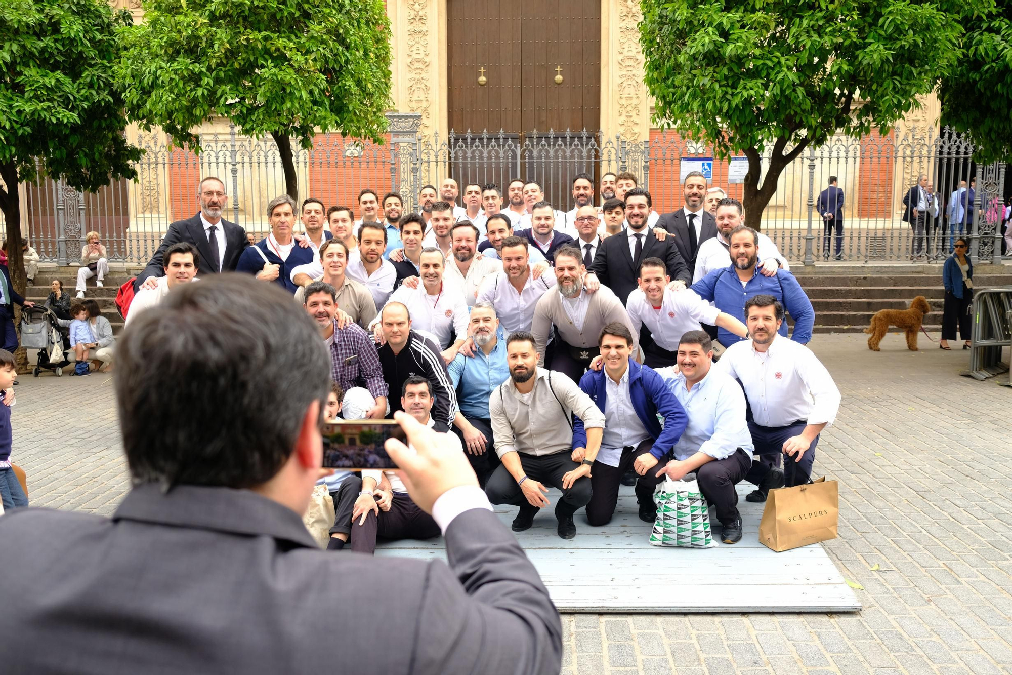 La cuadrilla de la Hermandad de la Cena se hace una foto delante del Salvador antes de iniciar su estación