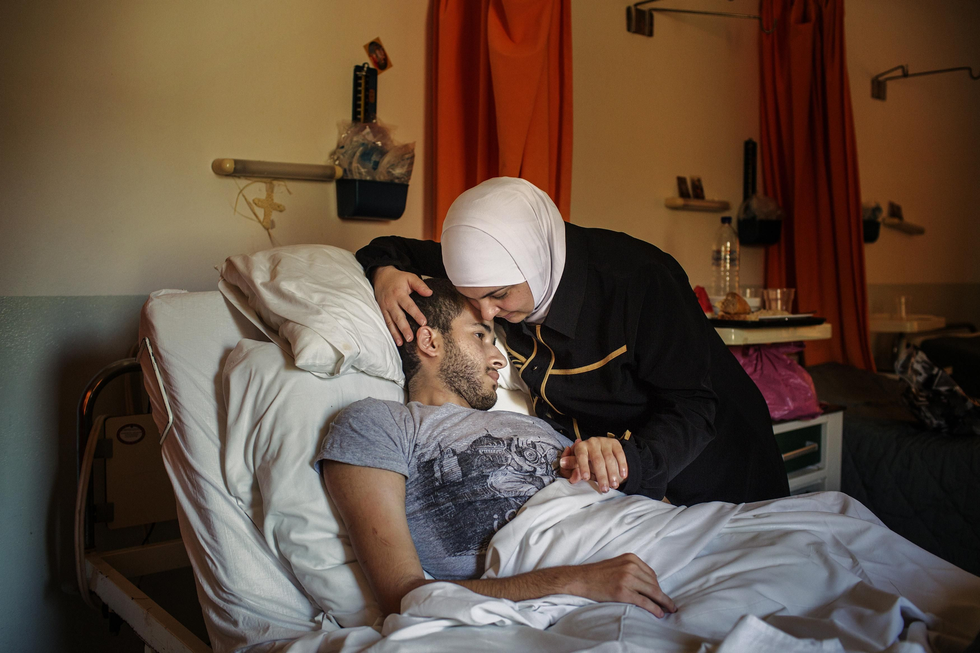 Ama Haider, 38 años, junto a su hijo Khalid Hamed, 22. Son de Damasco. Khalid nació con una discapacidad física. Ama: "Lo intentamos todo para llegar a Europa legalmente. Sabíamos que era arriesgado para nuestro hijo, que no puede caminar y necesita ayuda continua. También estaba preocupada por mis otros dos hijos, que tienen 15 y 10 años, pero en Turquía nadie nos ayudó”. Ama reconoce que, al final, eligieron la ruta más peligrosa, por mar. Establecieron contacto con los contrabandistas en Turquía y les explicaron su situación. Necesitábamos un barco con espacio y con una cama. Dijeron que podrían organizarlo pero que teníamos que pagar 10.000 dólares para poder viajar toda la familia. “Aceptamos. No teníamos otra opción – responde Ama - Nos fuimos por la noche. Empleamos cuatro horas para llegar a Kos, a Grecia. Tuvimos que subir un camino de tierra empinada. Mi esposo tiene 49 años y fue agotador; mi hijo le pidió que lo dejara allí. Por suerte, había otros sirios con nosotros, chicos fuertes y jóvenes que nos ayudaron. Calculo que al menos caminos 14 kilómetros". | Fotografía de Alessandro Penso/MSF.