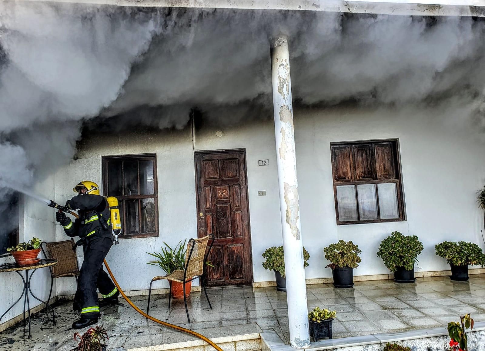 Un bombero apagando el incendio registrado en la mañana de este domingo en una vivienda situada en la zona de Tendiña (Los Llanos de Aridane). Foto: BOMBEROS LA PALMA