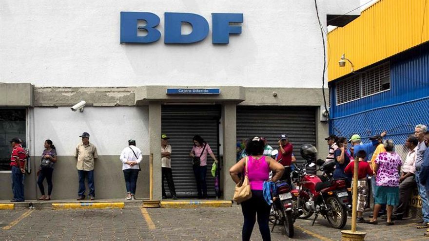 Varios adultos mayores hacen fila para retirar su pensión de jubilación en un banco este martes, en Managua (Nicaragua).