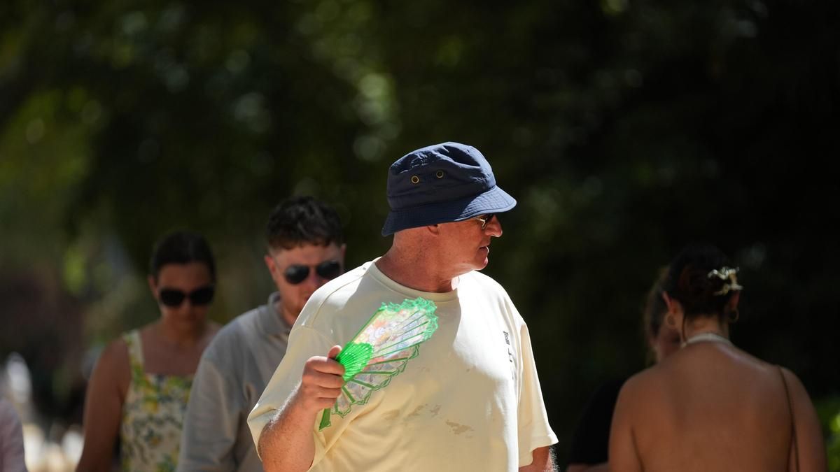 Un hombre con sombrero y abanico durante una jornada de intenso calor.