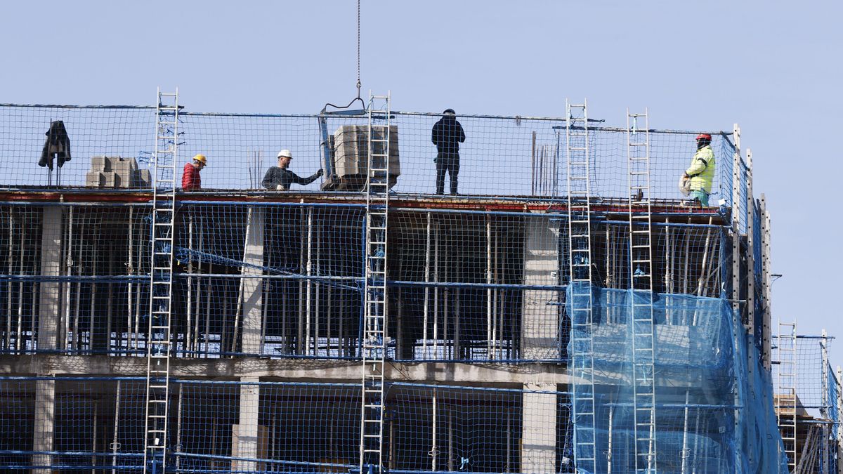 Imagen de archivo de empleados de la construcción levantando un edificio.