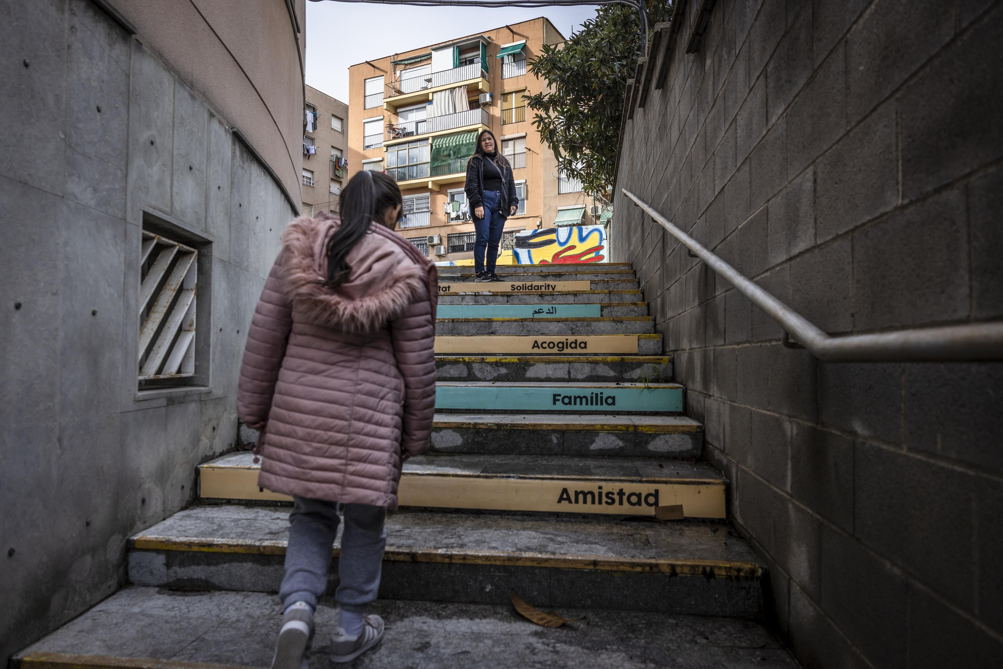 Karen y su hija, en las escaleras que llevan al Espacio Polivalente Santa Magdalena, en el barrio de Roquetes de Barcelona