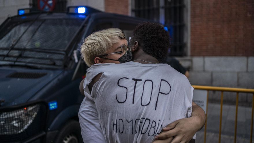 Dos jóvenes se abrazan ante a un furgón policial frente al ministerio de Justicia.
