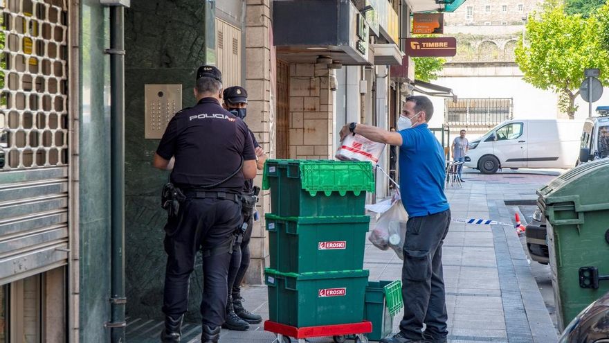 Miembros de la Policía Nacional hablan con un repartidor mientras montan guardia frente al edificio en la calle Nicolás Salmerón de Santander, en aislamiento por coronavirus.