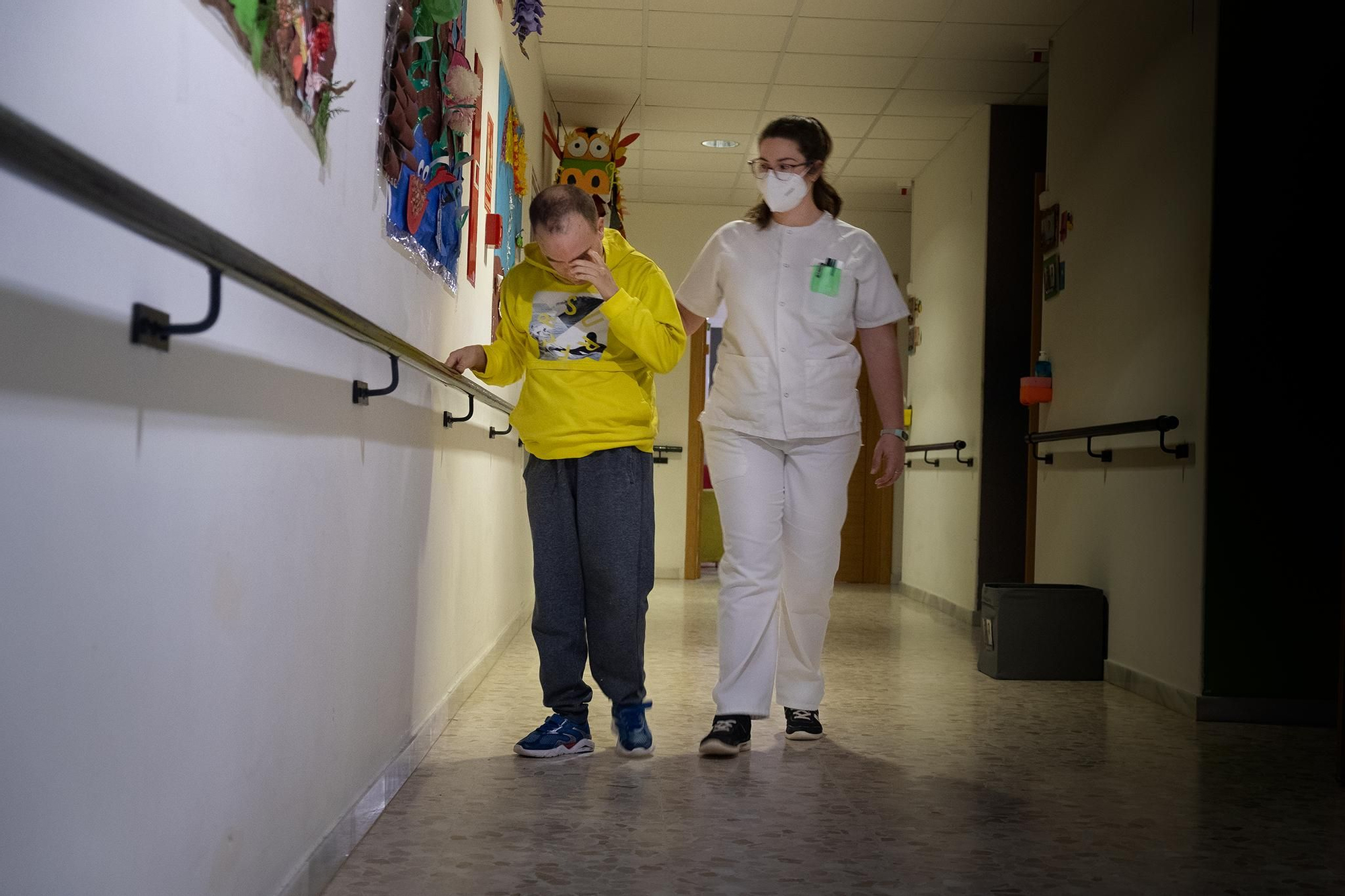 Samuel recorre el pasillo de las habitaciones junto a una mediadora