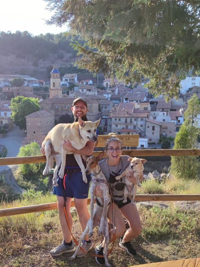 Javier y Ana posan junto a sus mascotas con el pueblo de Cabra de fondo