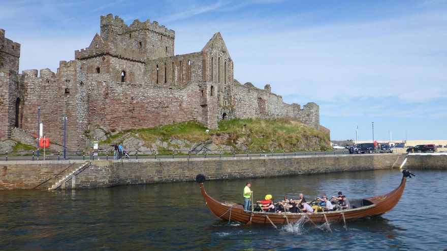 Un drakkar a remos pasa junto a los muros de Peel Castle, en la Isla de Man.