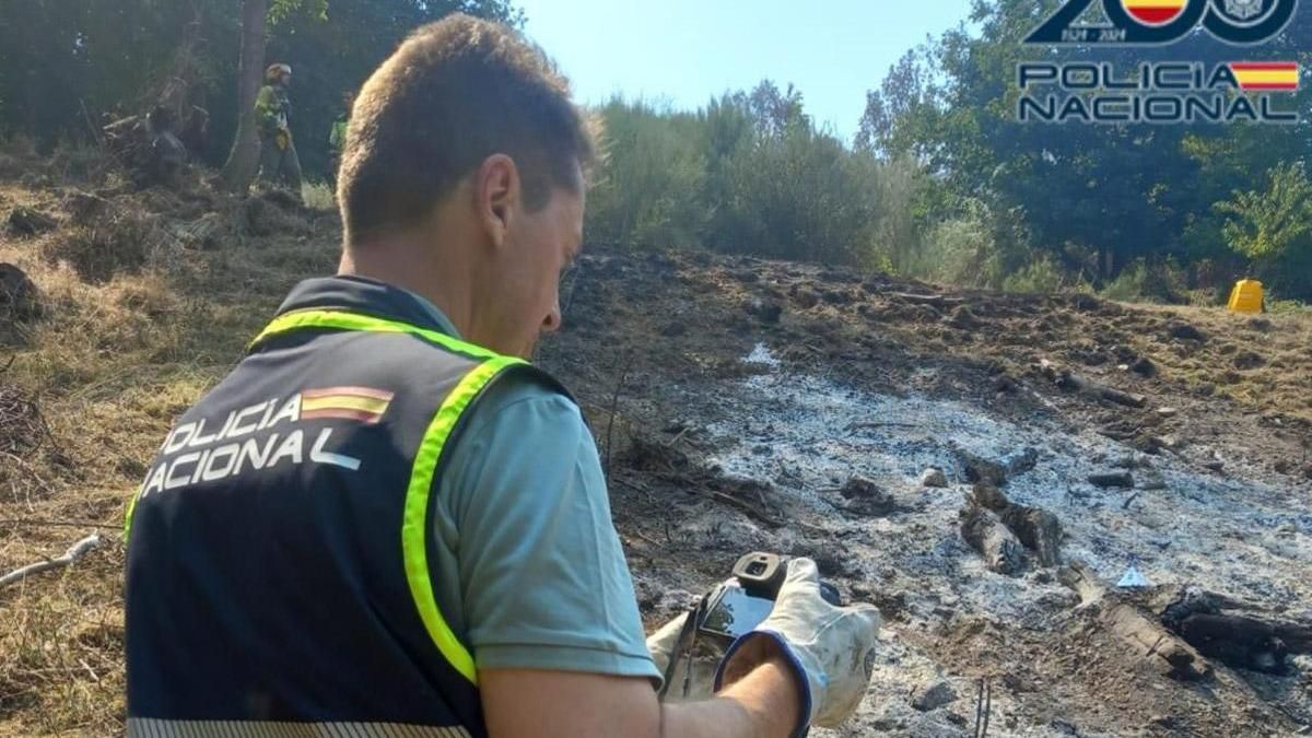 Un policía nacional obteniendo pruebas del incendio.