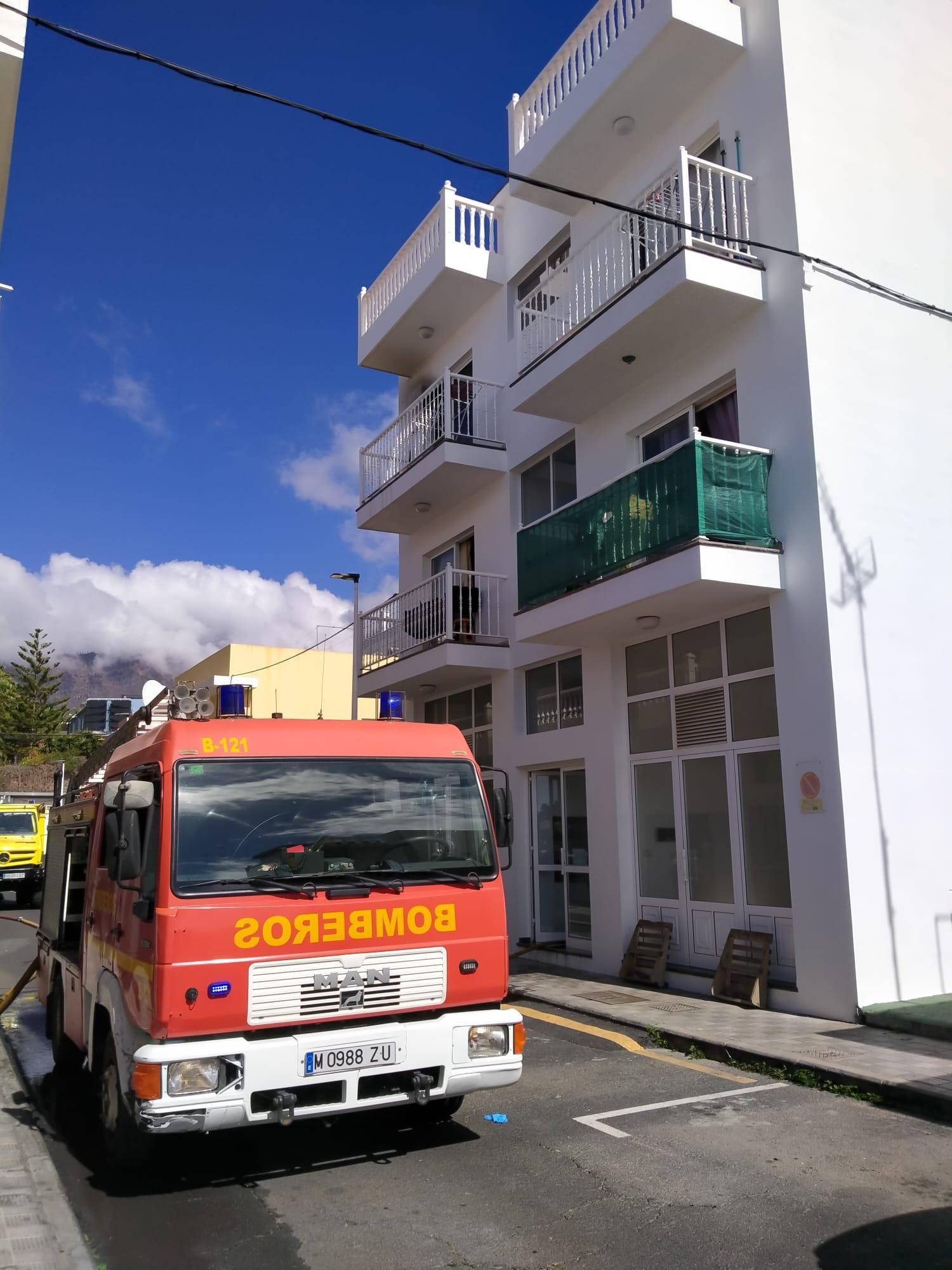 Un camión de Bomberos de La Palma junto al inmueble de la vivienda donde se registró el incendio en Los Llanos de Aridane.