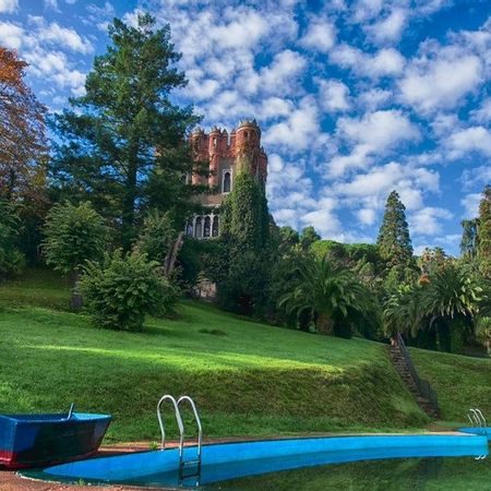 La piscina conectada con el mar Cantábrico en los jardines de Ocharán con el palacio al fondo.