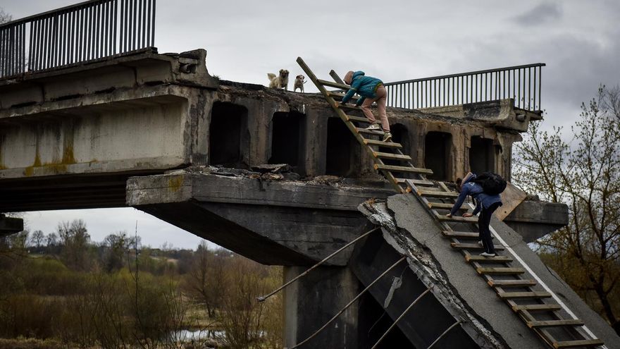 Kyiv (Ukraine), 19/04/2022.- Local citizen Natalia and her daughter climb a ladder, passing over a destroyed bridge in Kyiv (Kiev) area, Ukraine, 19 April 2022. On 24 February Russian troops had entered Ukrainian territory resulting in fighting and destruction in the country, a huge flow of refugees, and multiple sanctions against Russia. (Rusia, Ucrania)