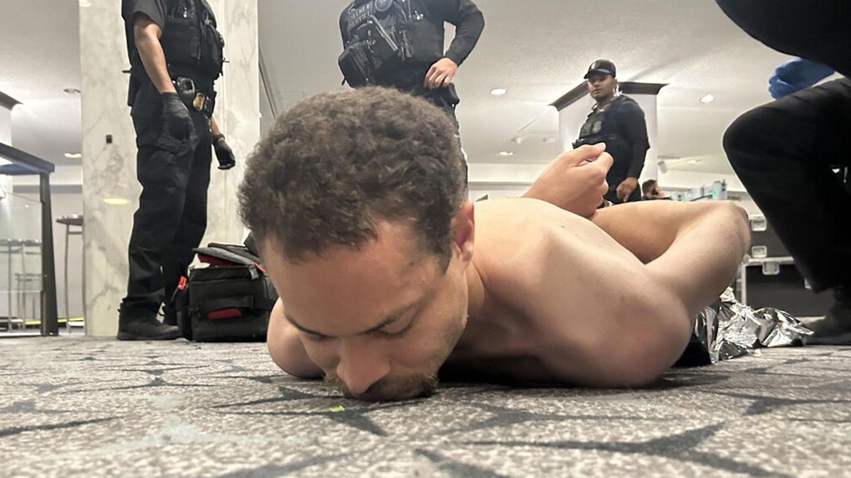 Fotografía difundida en la cuenta oficial de Trump en Truth Social donde se muestra al supuesto tirador arrestado por agentes del Servicio Secreto.