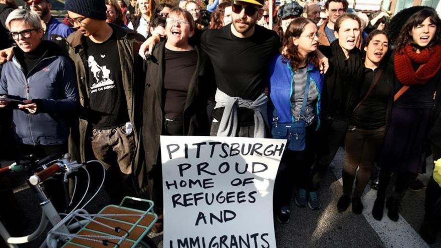 En la imagen el registro de un grupo de personas que exhiben un letrero en inglés que traduce: "Pittsburgh orgulloso hogar de refugiados e inmigrantes", durante una manifestación en contra de las políticas migratorias del presidente Donald Trump, en Pittsburgh (Pensilvania, EE.UU.).