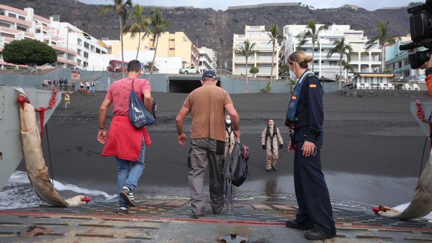 Dos de los seis agricultores bajan de la lancha en la playa de Puerto Naos para regar sus cultivos.