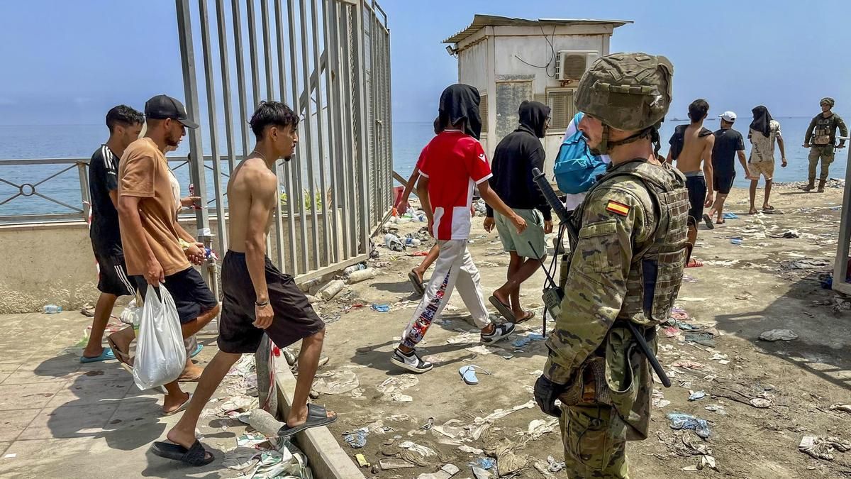 Varias personas migrantes regresan a pie a su país de origen (Marruecos), este viernes.
