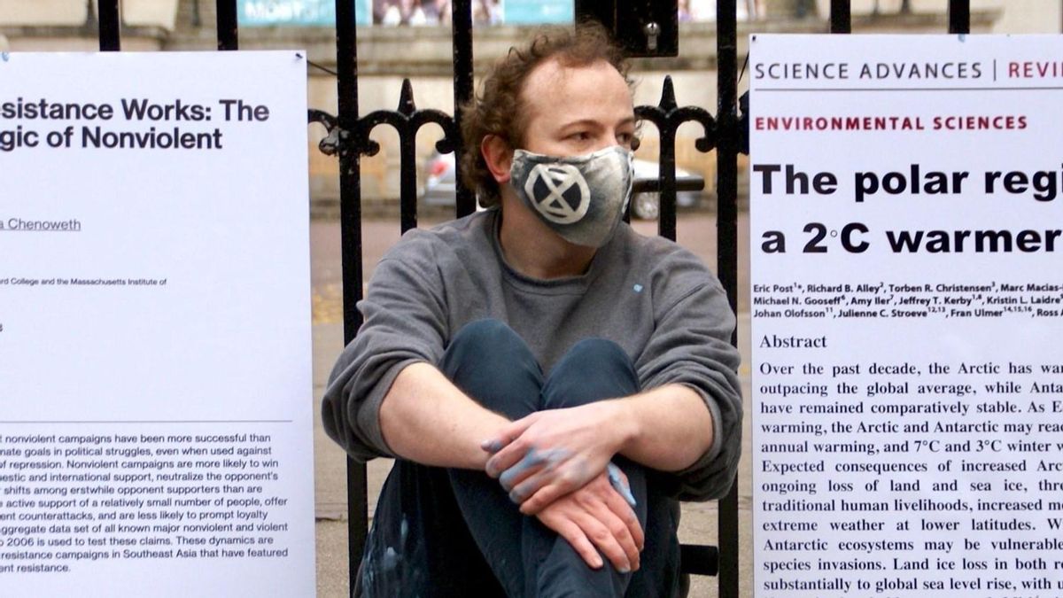 El activista Mike Lynch-White, sentado en la entrada de la Royal Society de Londres donde lanzó pintura verde con el colectivo Scientist Rebellion