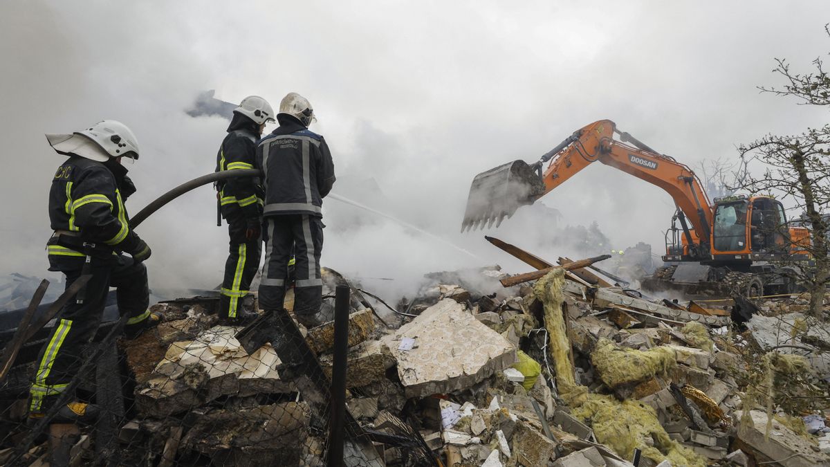 Un grupo de bomberos observa los escombros tras un ataque ruso en una zona residencial de Kiev el 25 de mayo.