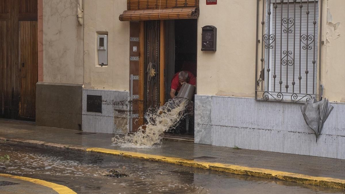 Un hombre achica agua, a 29 de octubre de 2024, en Llombai, Valencia