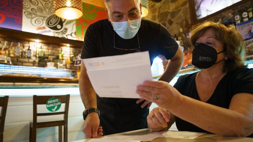 Personal de una cafetería de Santa Cruz de Tenerife, comprueba el certificado Covid de una clienta.