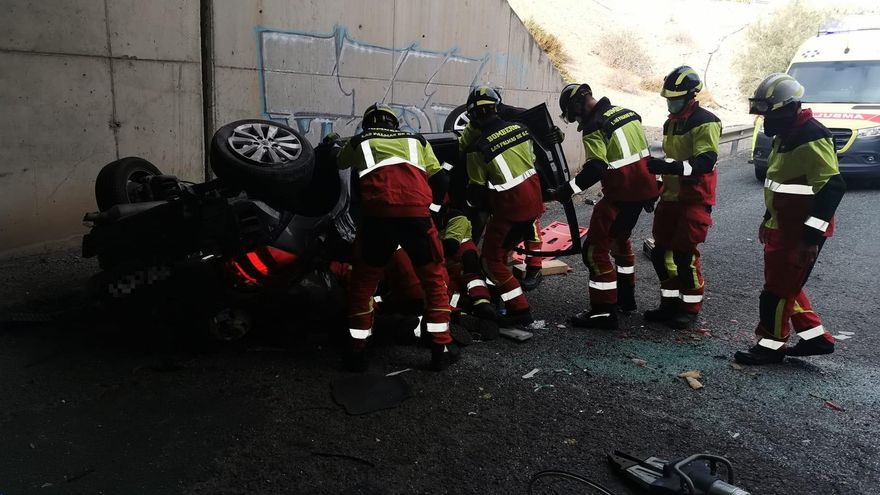 Bomberos, trabajando para liberar a la mujer que quedó atrapada en su vehículo