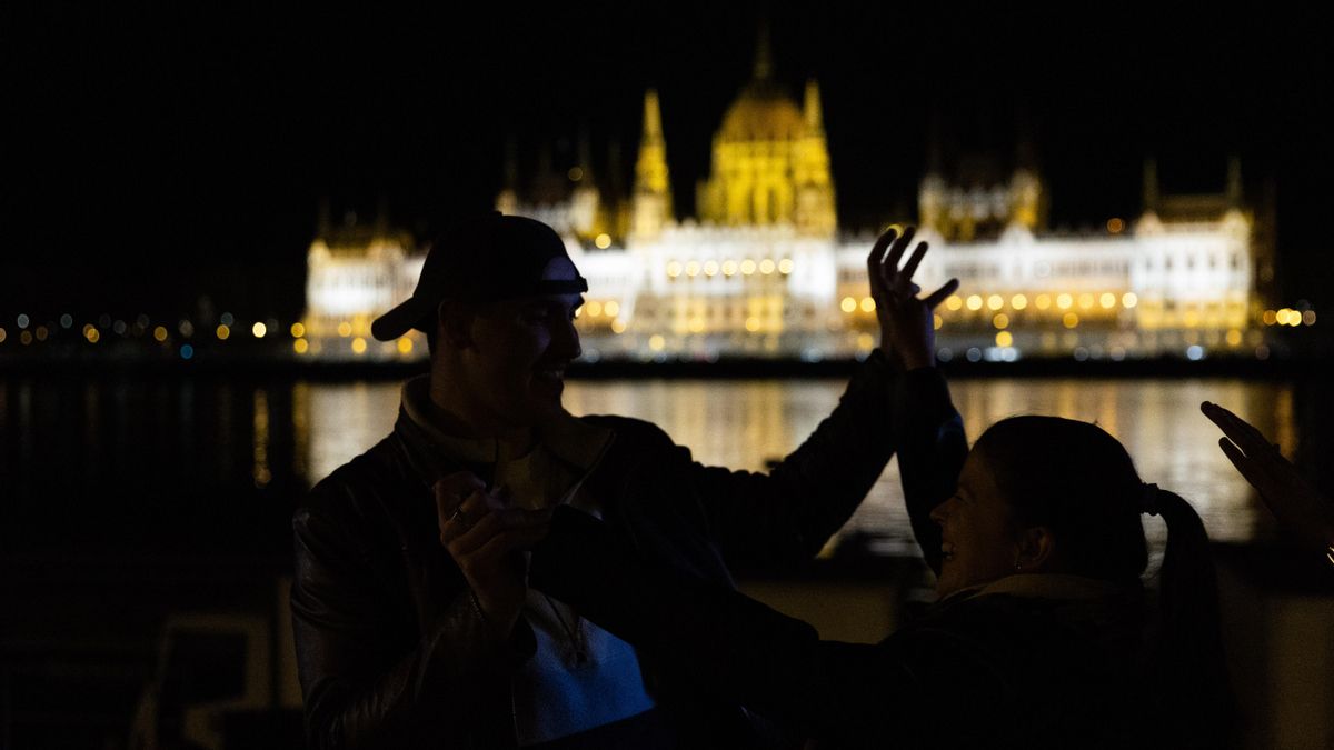 Varios jóvenes bailan encaramados a la orilla del Danubio frente al Parlamento