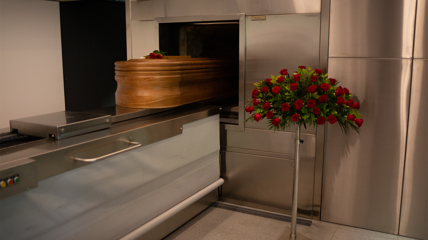 Un ataúd, ya desinfectado, de una víctima con Covid-19, es introducido en el horno crematorio. Archivo
