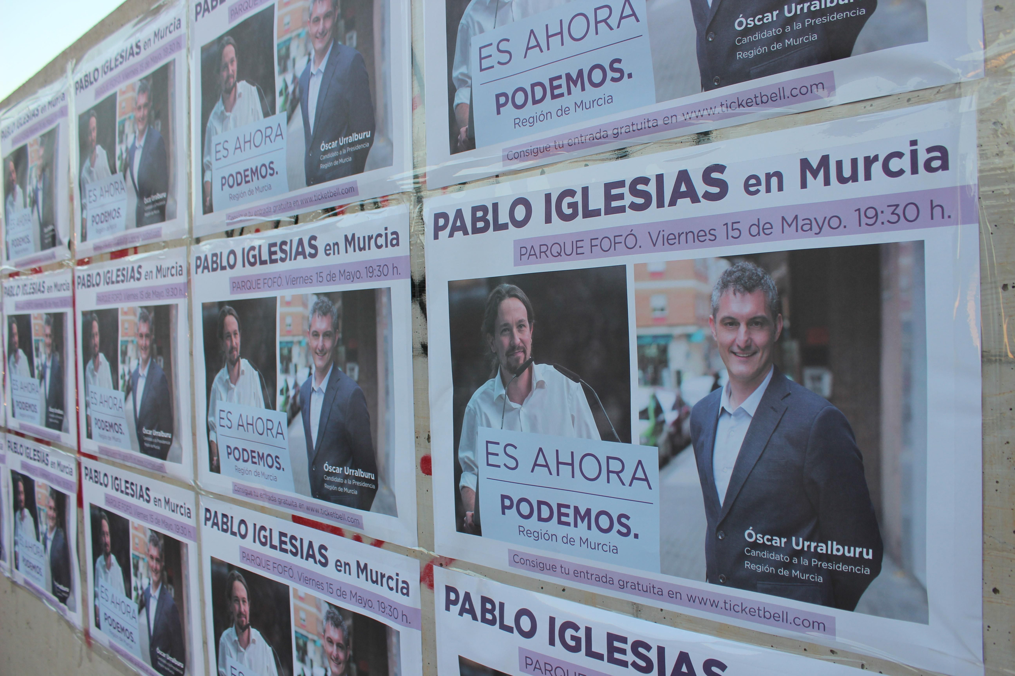 Carteles con Pablo Iglesias y Óscar Urralburu, junto al escenario del acto de Podemos / PSS