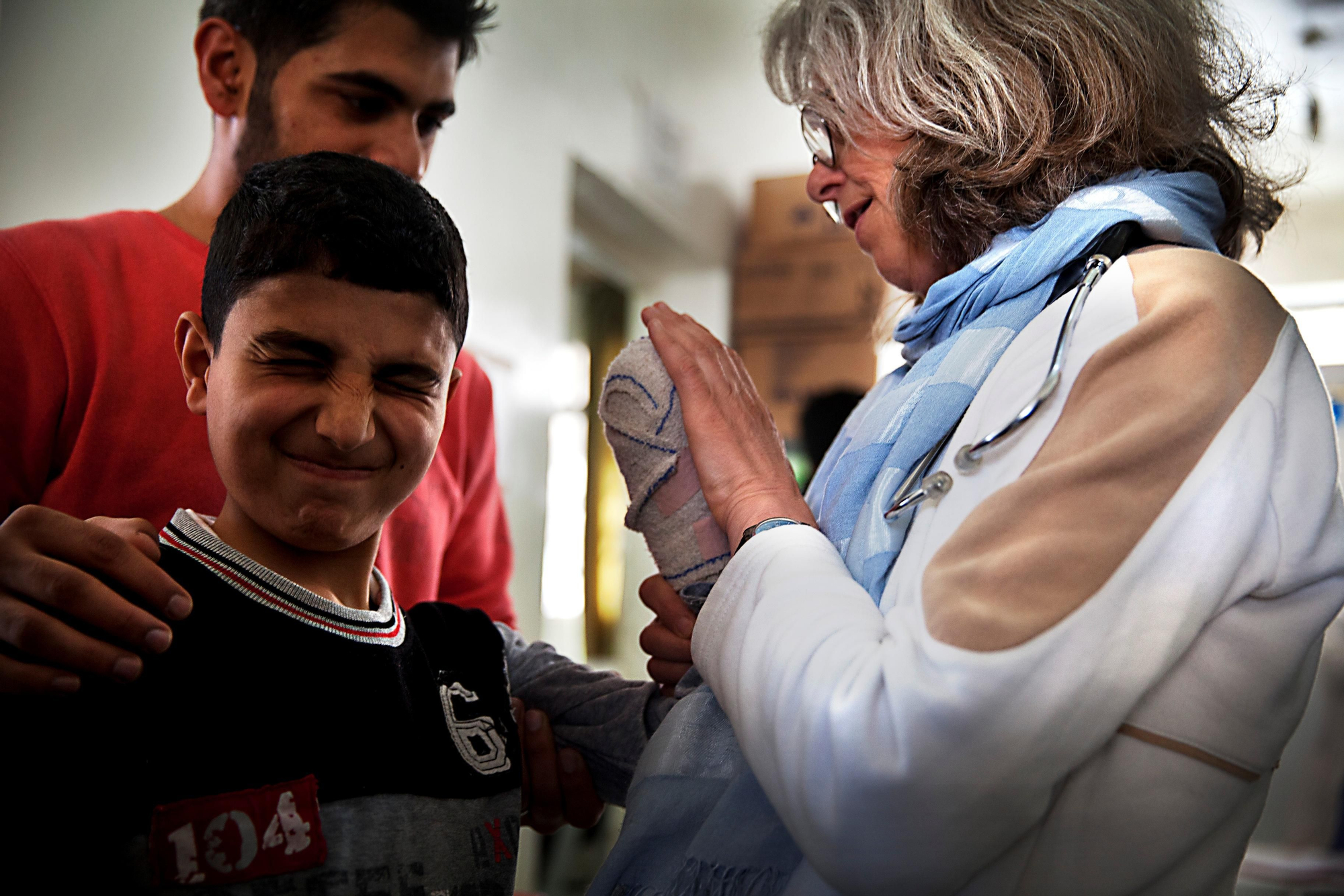 Una cirujana de Médicos Sin Fronteras comprueba el estado de la mano de un niño sirio que perdió los dedos en un accidente. En el hospital no solo se atienden a heridos, sino a embarazadas y personas con enfermedades crónicas. Fotografía: Anna Surinyach /MSF