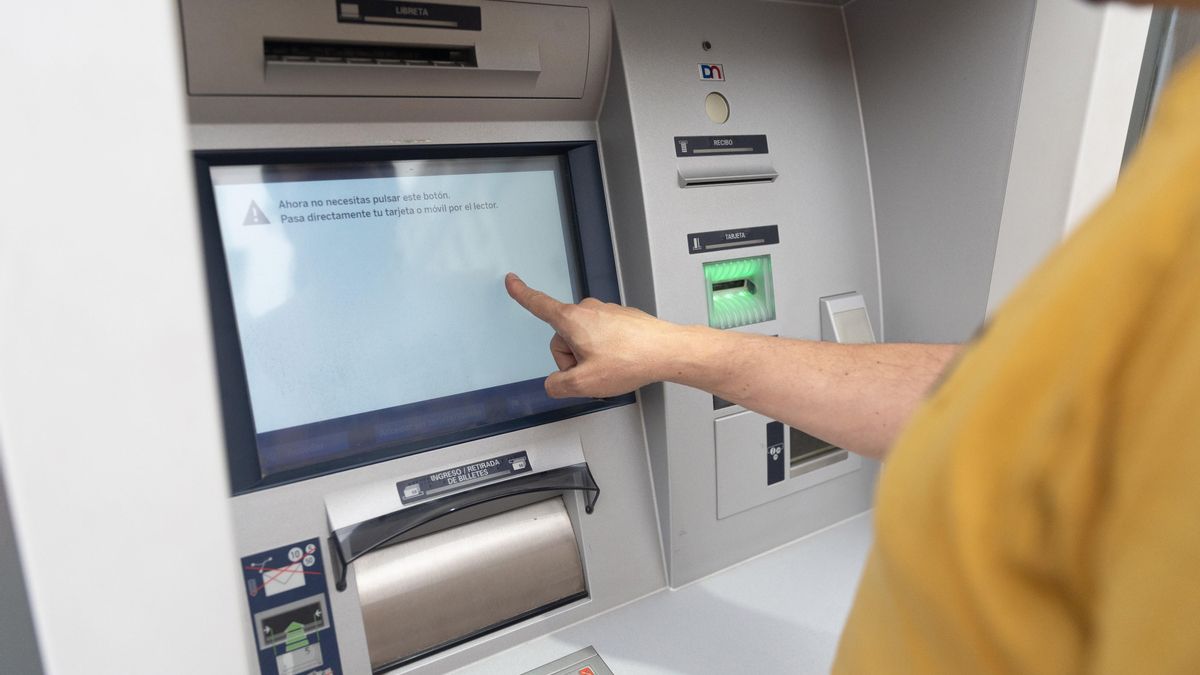 Un hombre, utilizando un cajero automático, en una imagen de archivo.