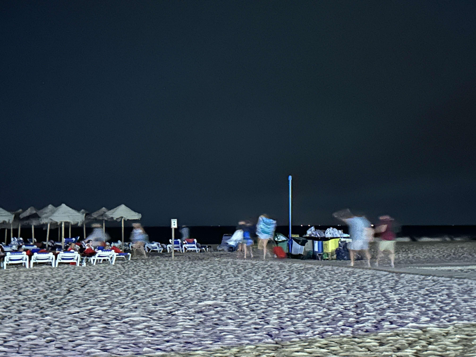 Veraneantes seek to spend the night on the beach of Zahara de los Atunes because of a forest fire, on August 12, 2025.